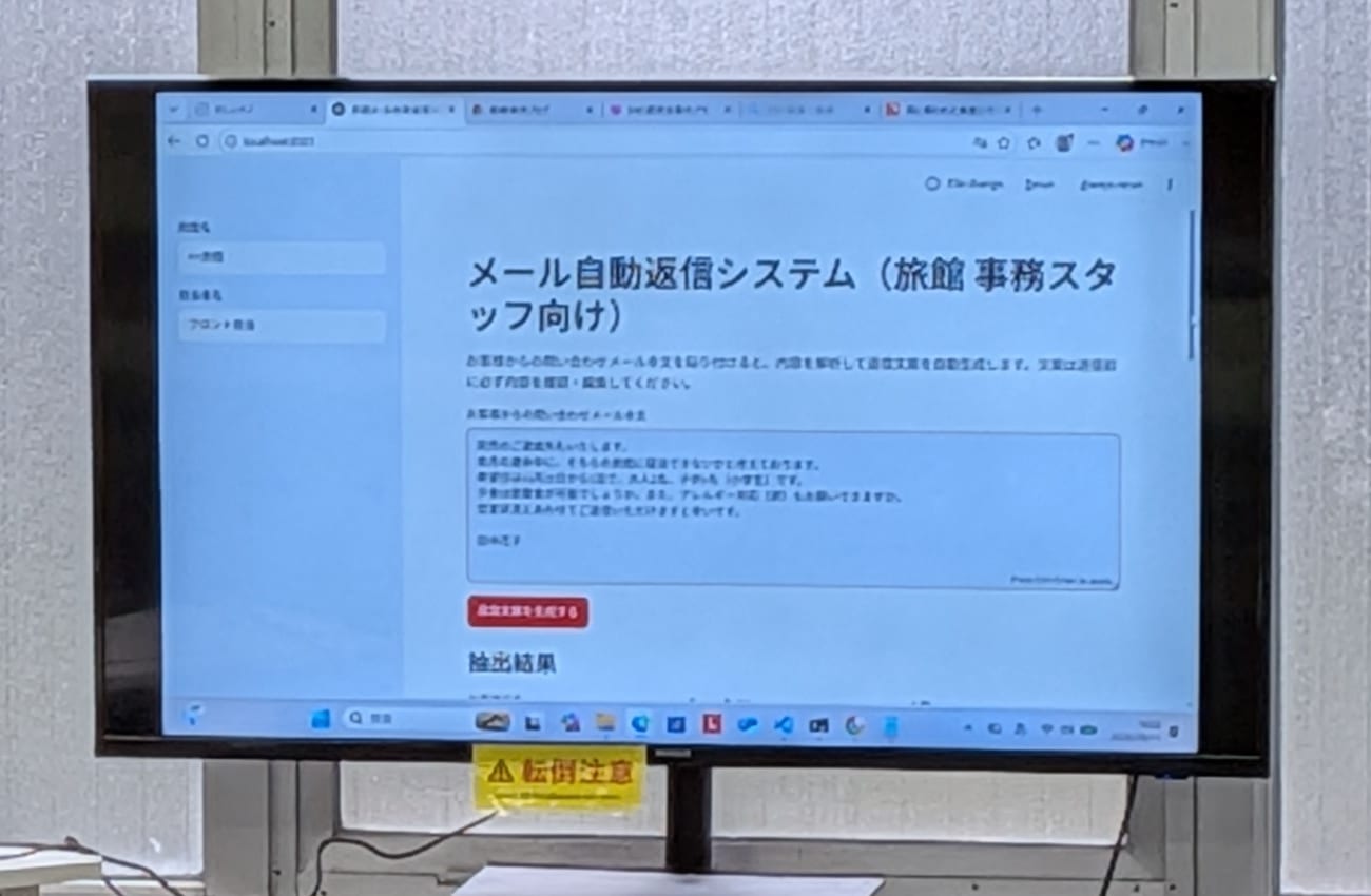 大型モニターに映した「メール自動返信システム(旅館 事務スタッフ向け)」の画面